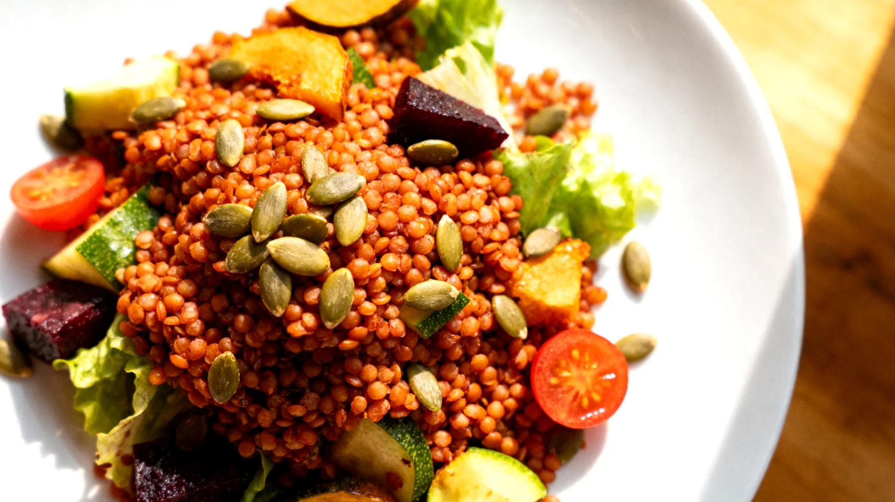 Insalata di lenticchie rosse con verdure croccanti e semi di zucca"